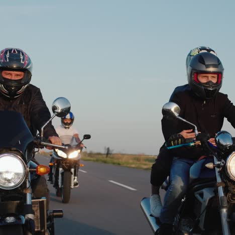 a group of bikers drives along the highway among the fields on a clear autumn day 1