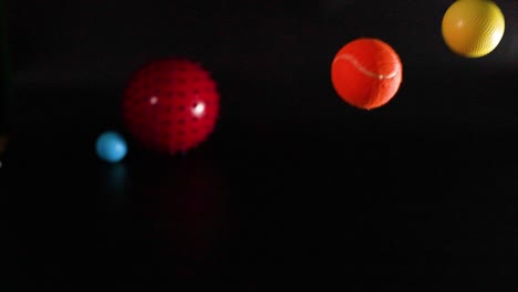 various colored balls moving against a dark background