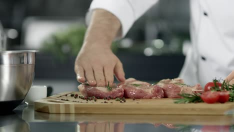 Chef-male-preparing-meat-at-kitchen.-Closeup-chef-hands-preparing-steak.