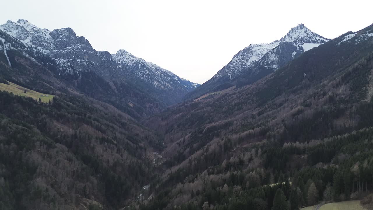 vista aérea del paisaje montañoso con montañas cubiertas de nieve y bosque en invierno, austria, video de 4k 30 fps