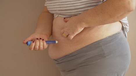 woman applying diabetes medicine into her belly in slow motion