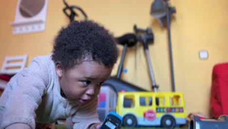 two year old exotic afroeuropean child playing at home with his toy train