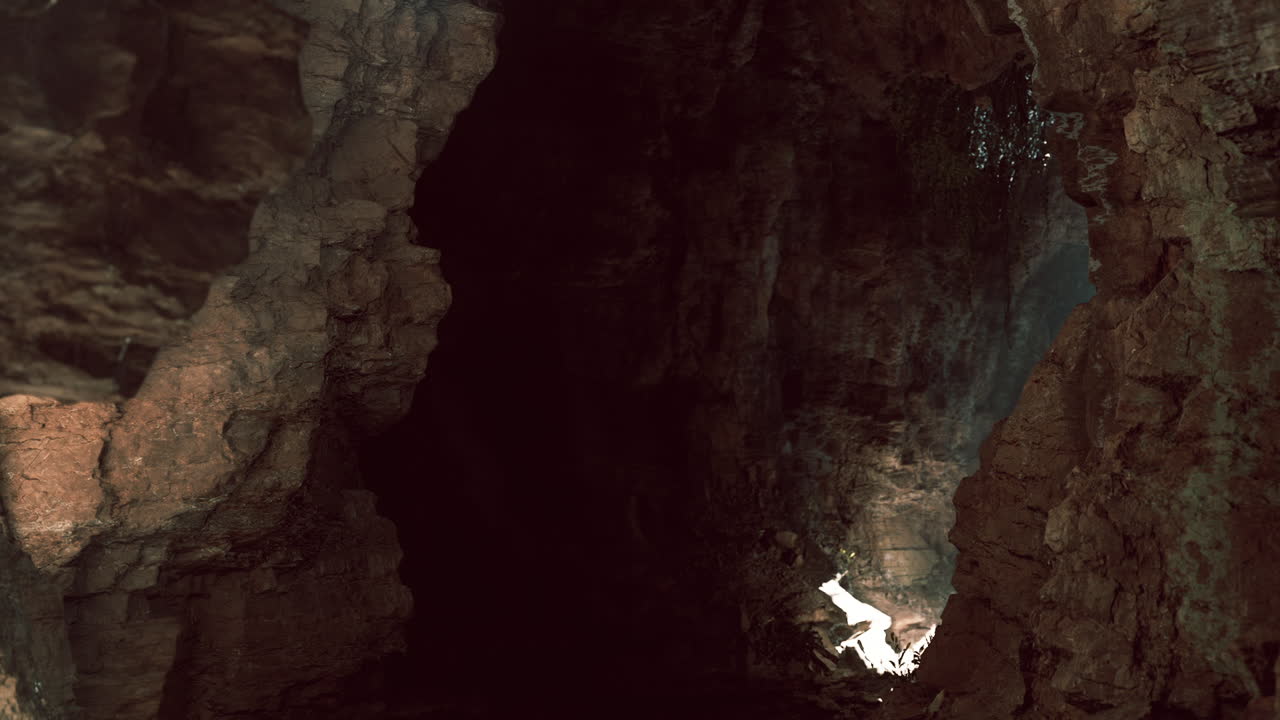 Exploring a mysterious cave illuminated by sunlight in a remote location