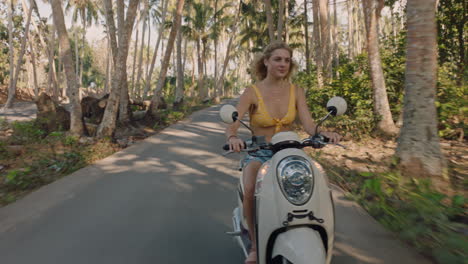 mujer feliz montando una motocicleta en un viaje por carretera a una isla tropical disfrutando de un paseo en motocicleta en vacaciones de viaje