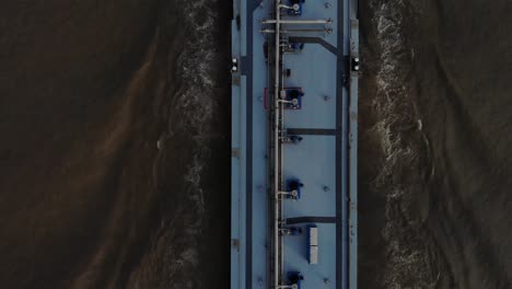 Schwer-Beladener-Blauer-Tanker,-Der-Auf-Einem-Dunkel-Gefärbten-Fluss-Vorwärts-Segelt-Und-Dabei-Sein-Navigationsradar-Nutzt