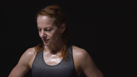 Studio-Portrait-Of-Mature-Woman-Wearing-Gym-Fitness-Clothing-Sweating-After-Exercise