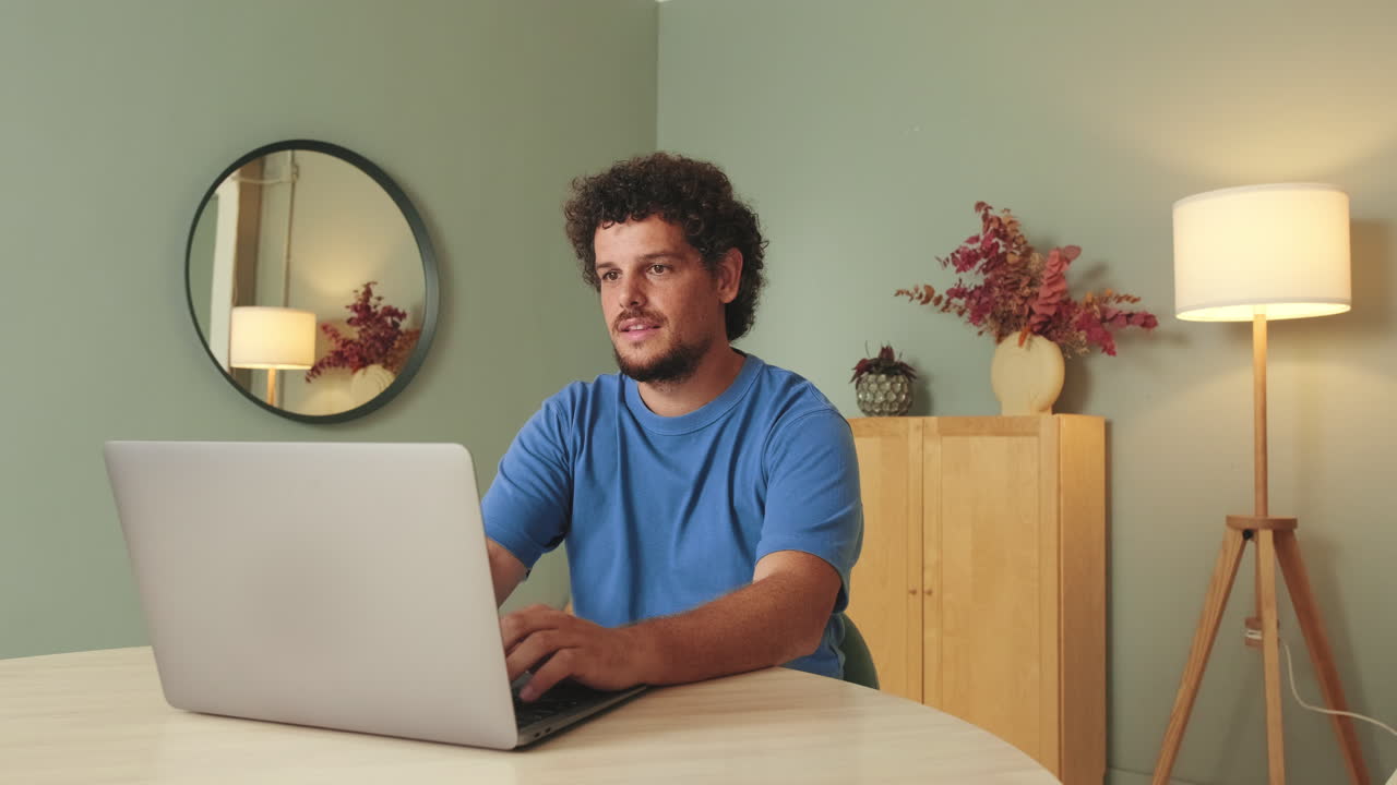 Uomo concentrato che usa il laptop per smart working a casa
