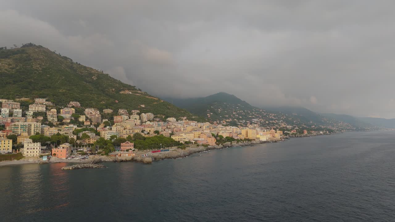 Veduta aerea della costa di Genova con edifici e cielo cupo, luce serale