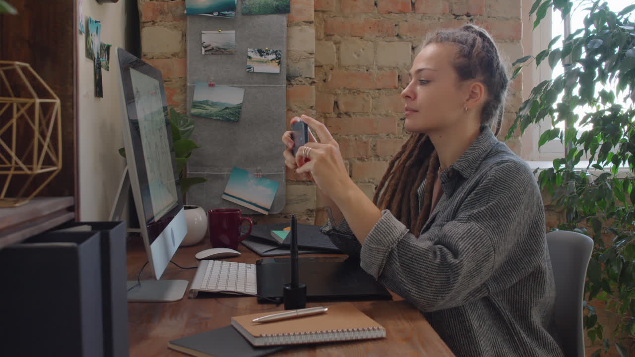 Graphic Designer Taking Picture Of Her Work