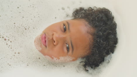 un niño afroamericano feliz tomando un baño y cantando