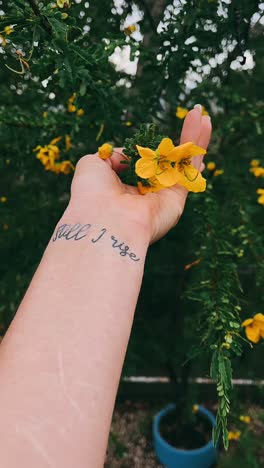 motivational tattoo of "still i rise" with flowers