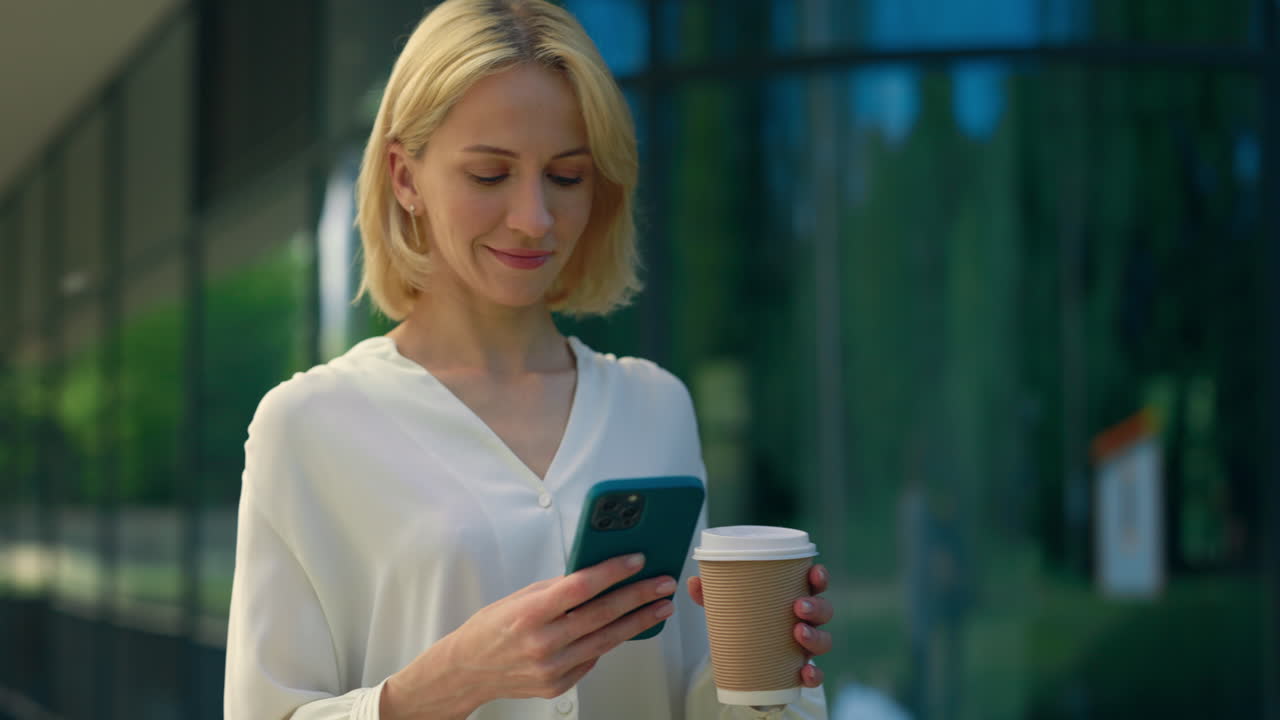 Donna che usa il telefono all'aperto con caffè