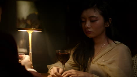 sad woman in a bar sitting across from partner, deep in thought, emotional mood