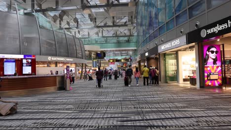 passengers walking through a busy airport terminal