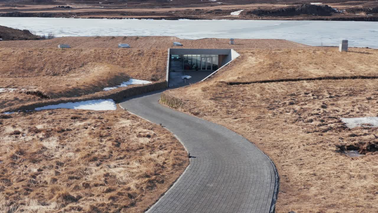 camino que conduce a un edificio natural moderno con techo de hierba, vok spa islandia