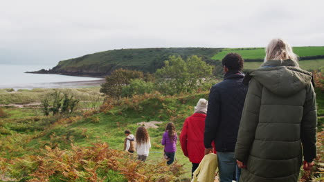 Vista-Trasera-De-Una-Familia-Activa-Multigeneracional-Caminando-Por-El-Sendero-Costero-De-Otoño