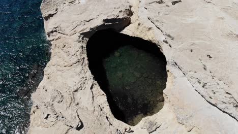 Eine-Langsame-Drohnenbewegung,-Um-Das-Loch-Im-Küstenvorland-In-Der-Nähe-Des-Strandes-Von-Saint-Antoine-Auf-Korsika-Zu-Enthüllen