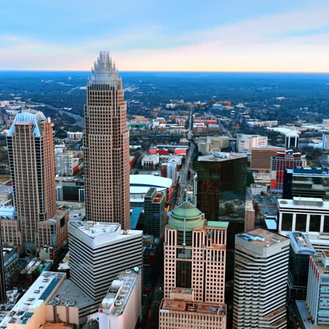 drone approaching the group of high-rise buildings built close to each other in the city downtown. view of north carolina, usa from aerial perspective.