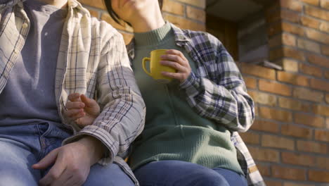 백인 부부 가 시골 집 밖 에서 차 를 마시면서 대화 하는 클로즈업 화면