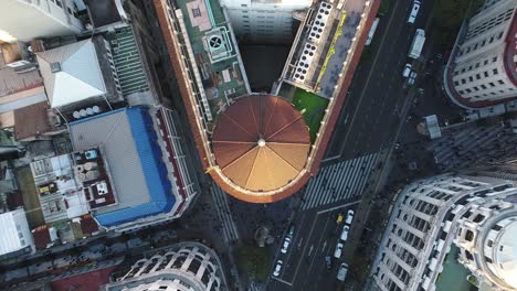 vista aérea fija de una cúpula rodeada de calles con actividad vehicular y peatones en movimiento