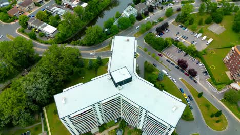 Laval-North-Shore-homes-condos-next-to-the-river-with-boats-docked-for-public-and-private-use-as-light-traffic-dives-by-a-quiet-summer-afternoon-dolly-roll-at-a-y-building-white-lush-greenery-YULD3-3