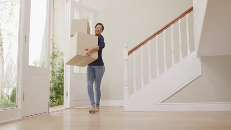 Young-woman-carrying-cardboard-boxes-and-putting-inside-the-house