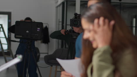 director de cine hablando con actores masculinos y femeninos sosteniendo guiones ensayando para filmar una película o video en el estudio 1
