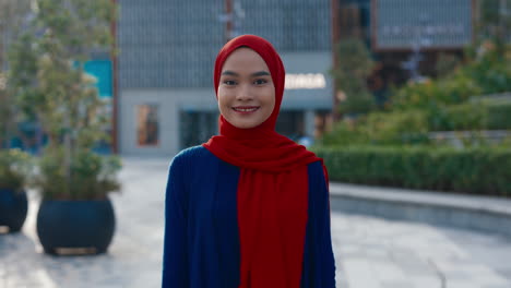 smiling young muslim woman in red hijab outdoors