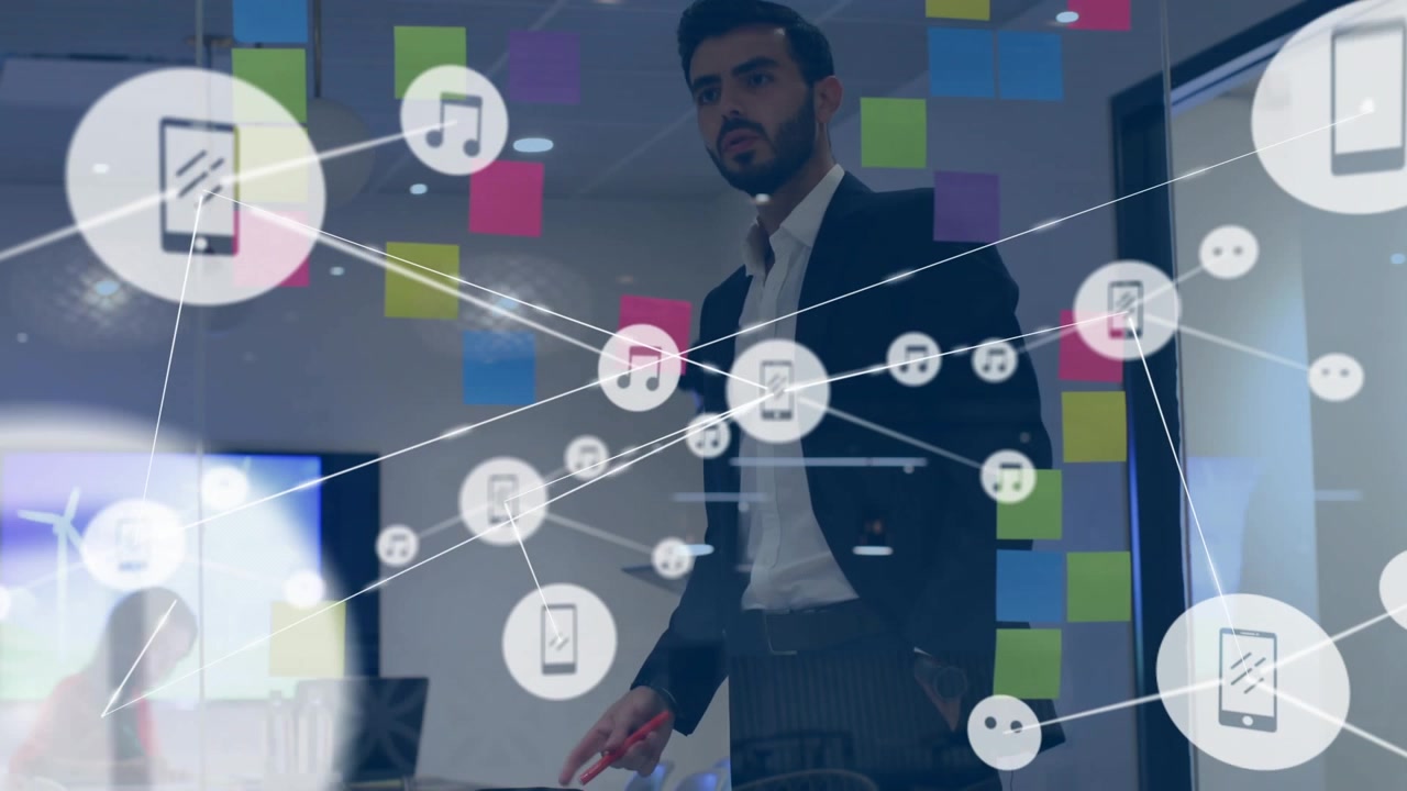 Icons appearing, man in dark suit pointing at glass partition, explaining network with red marker