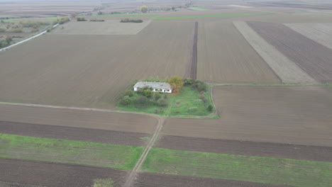 tierras de cultivo desnudas marrones fuera de temporada rodean un gran dron rural de granja blanco