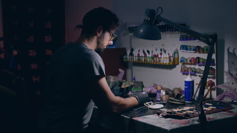 painting workshop man painting a small 3d printed object long shot