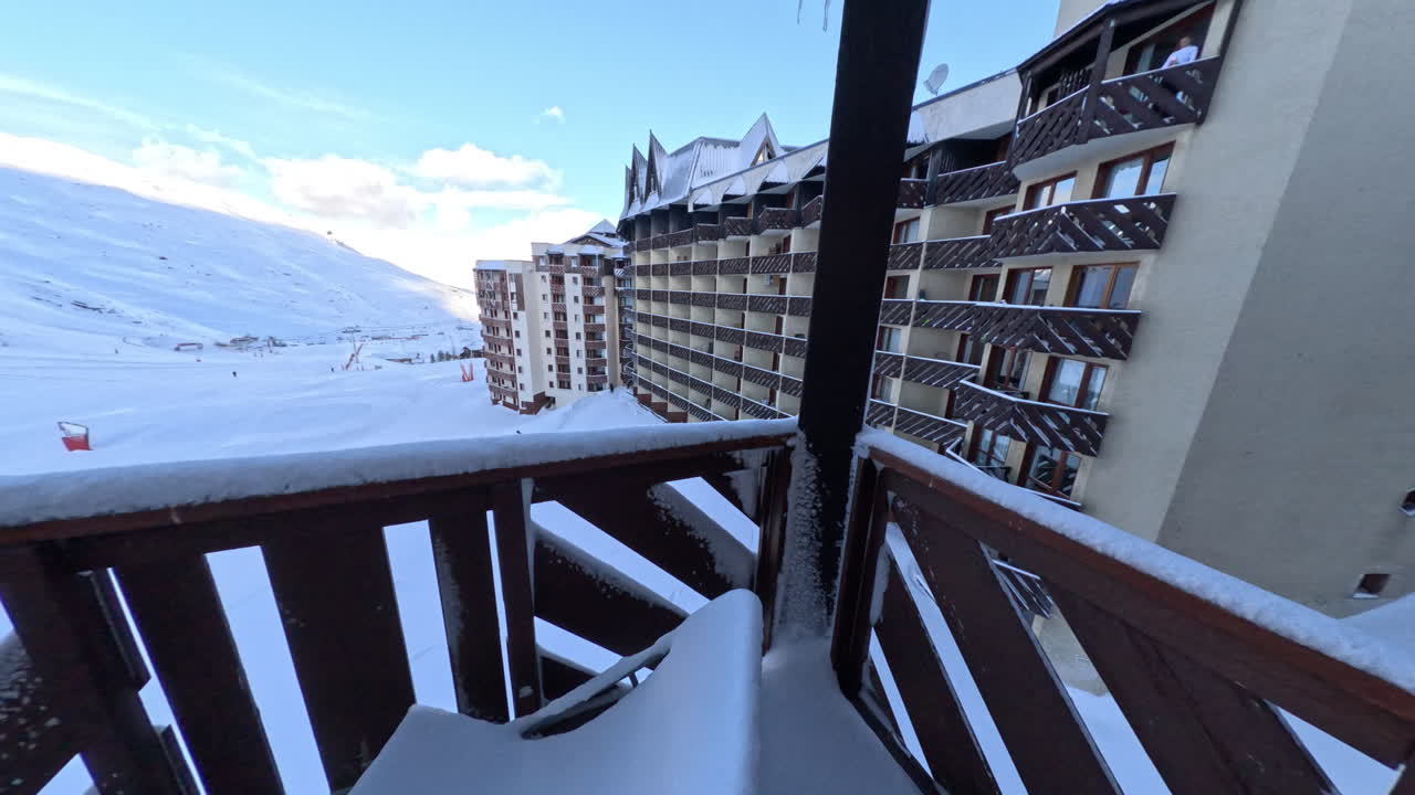 Walking out onto apartment balcony in ski resort after a fresh dump of snow