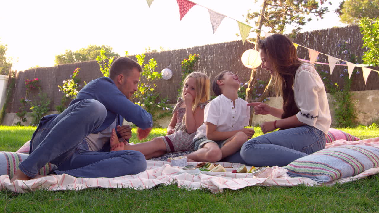 정원 에서 담요 에 피크닉 을 즐기는 가족