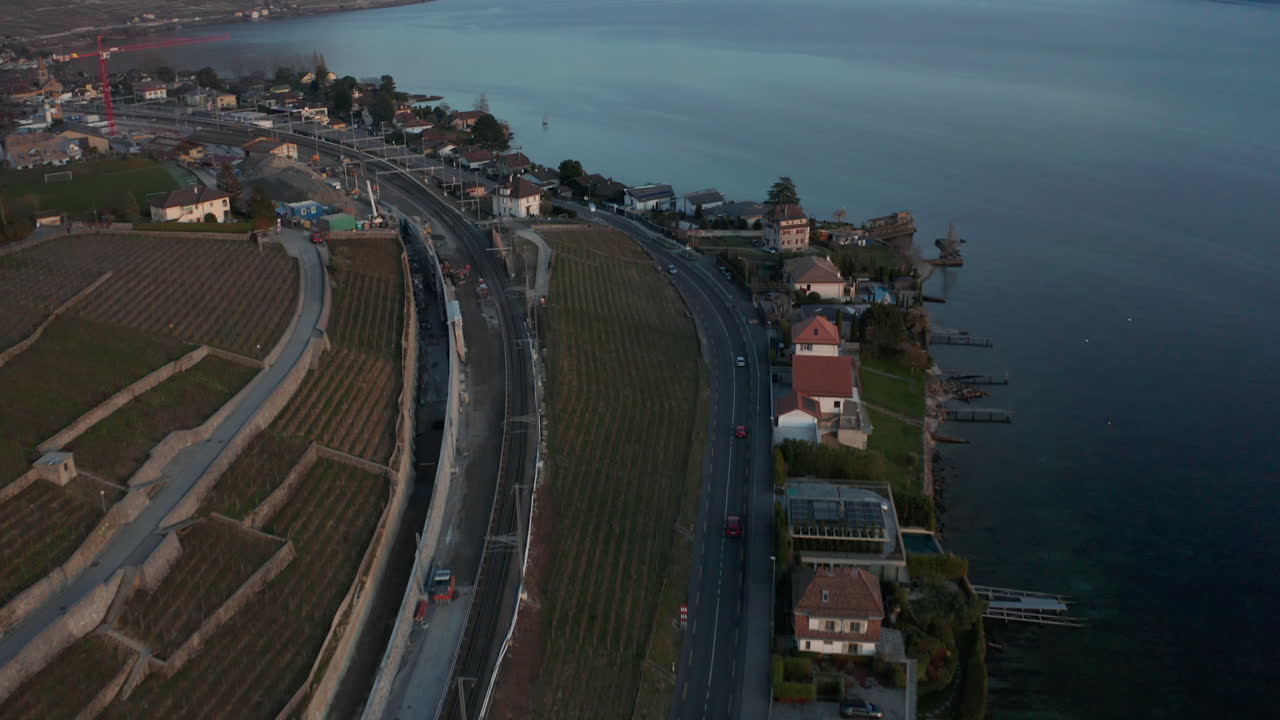 Aerial of traffic driving over highway, tilting up and revealing stunning vast lake