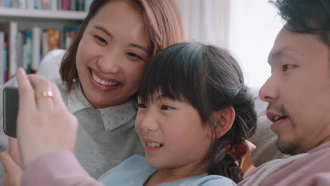 happy asian family having video chat using smartphone at home mother and father with daughter chatting on mobile phone together waving hand enjoying online communication 4k footage