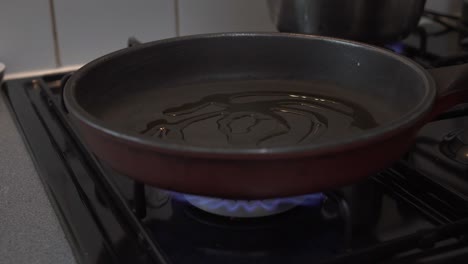 Koch-Gießt-Olivenöl-In-Eine-Heiße-Pfanne