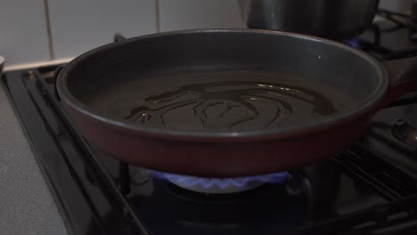 chef pouring olive oil in a hot pan