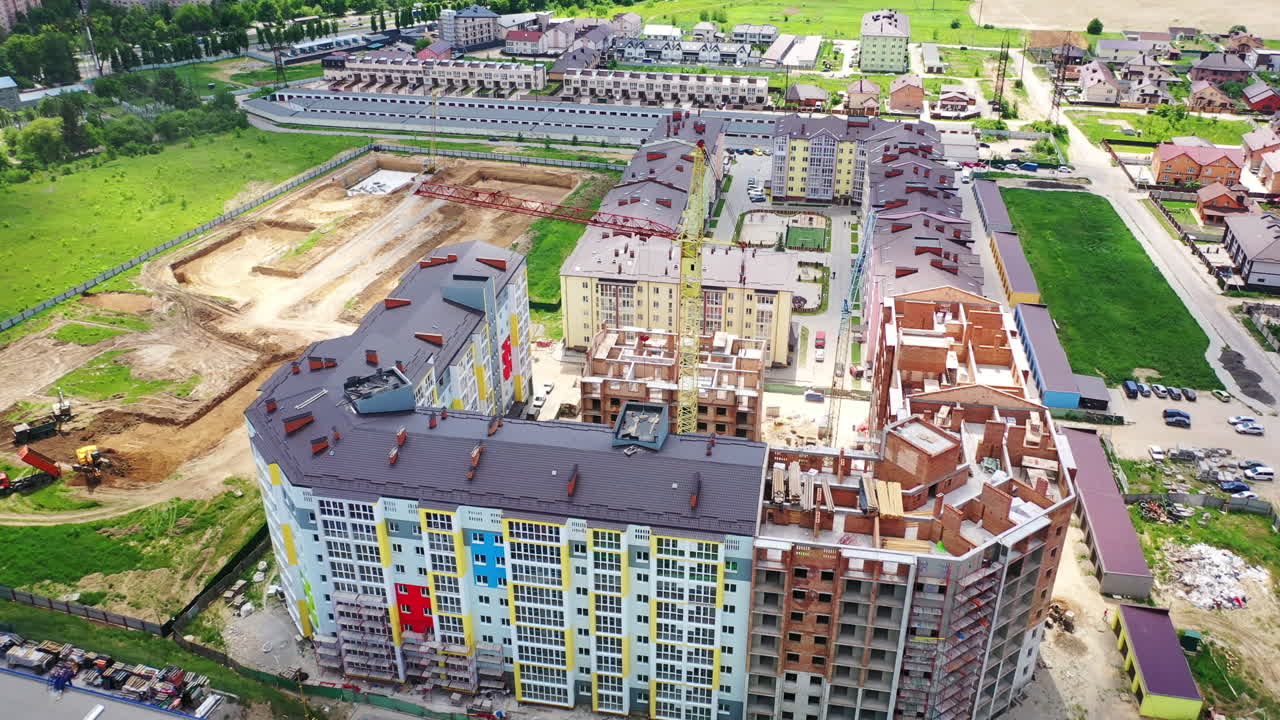 Modern construction area in the city. New residential complex is building in summer. Tower crane in a construction site.