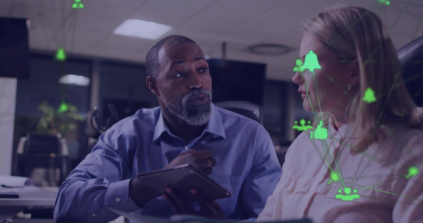 Senior man tapping tablet and explaining business data, initiating green network overlay with icons