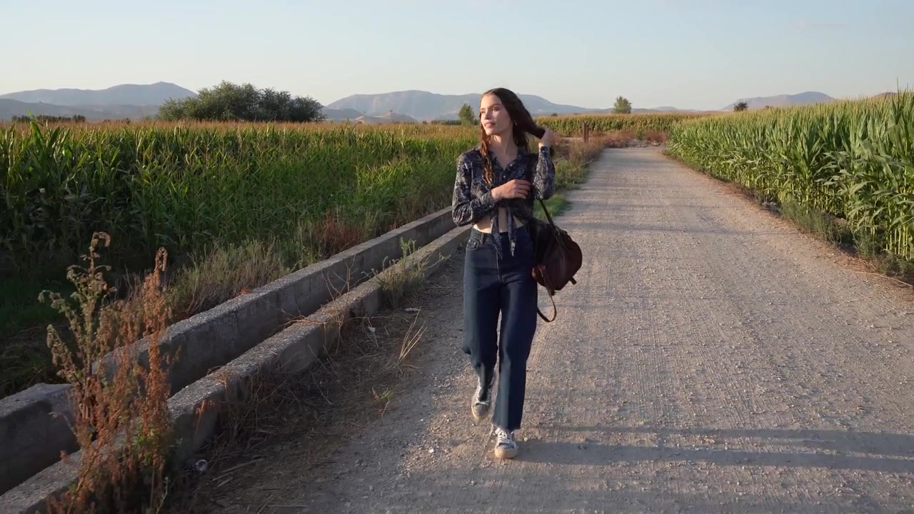 Una donna passeggia in un vigneto, assaporando il paesaggio e godendosi l'aria fresca.