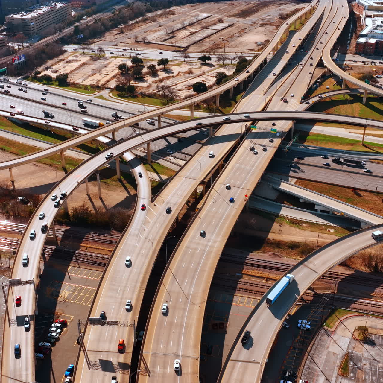 Roads, freeways and moving transport in the busy modern city. Sunny view of Dallas, Texas, USA from top