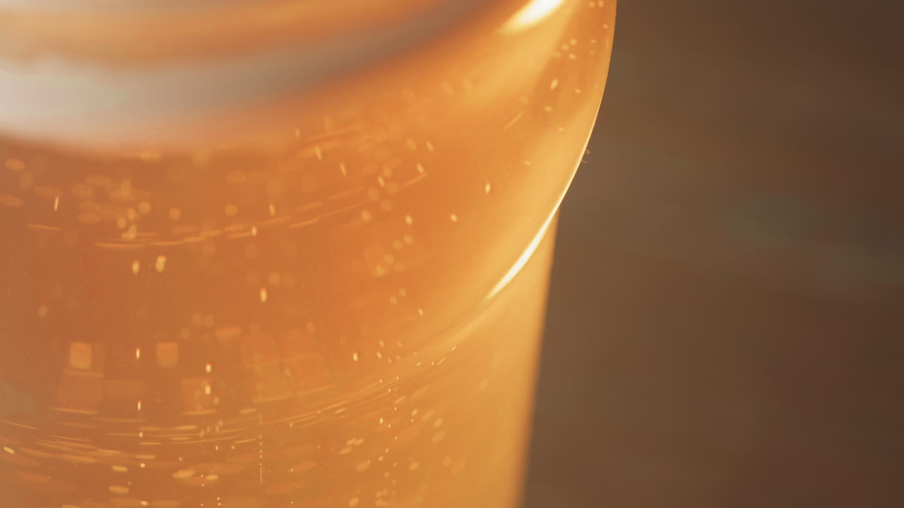Beer bubbles float up to the head on a curved pint glass, with copy space
