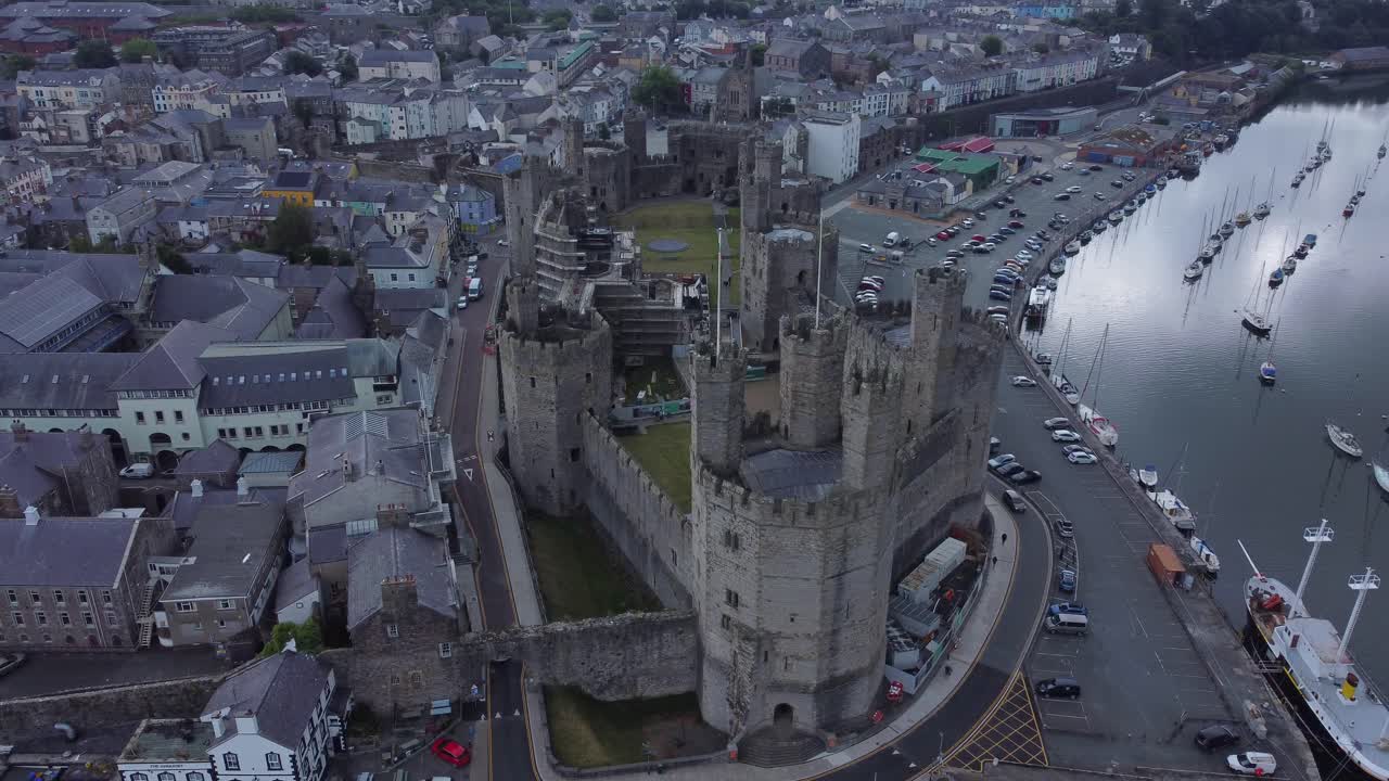Antico castello di Caernarfon, città portuale gallese, vista aerea del lungomare medievale con inquadratura orbitale a destra.