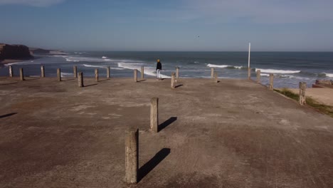 Person-walking-on-seafront-abandoned-building