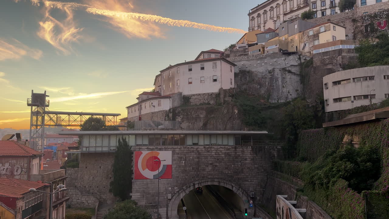 Wide shot of Ribeira’s hillside architecture beneath the Serra do Pilar Monastery during sunset in Porto, Portugal