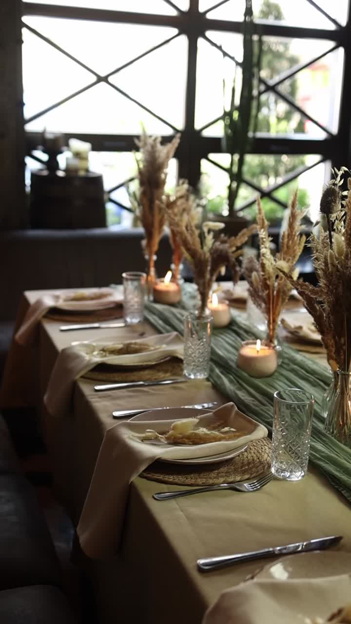 Elegantly Set Dining Table with Candles and Dried Floral Decorations