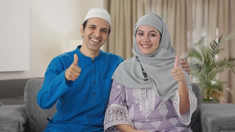 happy muslim couple showing thumbs up