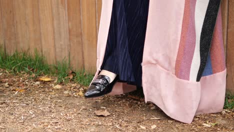 woman in a pink coat and velvet pants