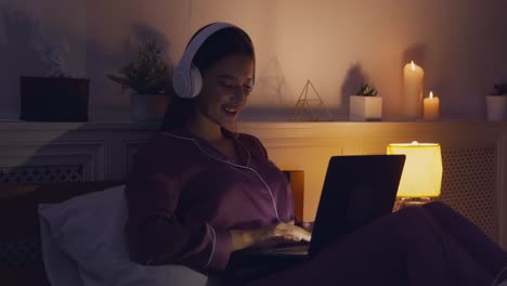 woman working on laptop in bed at night