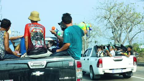 people enjoying water fights from pickup trucks